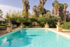 a swimming pool in a yard with palm trees at Tenuta Donna Vittoria in Trapani