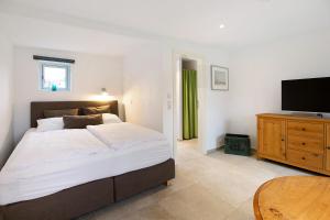 ein Schlafzimmer mit Bett und Flachbildfernseher in der Unterkunft Lüttdeel in Gelting