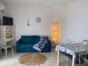 a living room with a blue couch and a table at Casa Orimar 419 in Badesi