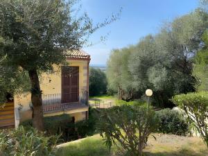 a house with a balcony in the middle of a garden at Casa Orimar 419 in Badesi
