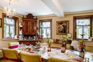 a dining room with a table and chairs and windows at Ferienwohnung-Cottage Rhöner Kräute in Buttlar