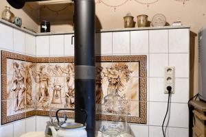 a stove in a kitchen with reliefs on the wall at Ferienwohnung-Cottage Rhöner Kräute in Buttlar