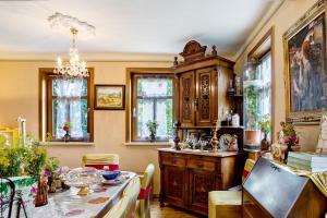 a dining room with a table and a large wooden cabinet at Ferienwohnung-Cottage Rhöner Kräute in Buttlar +37 photos