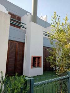 a white house with a fence in front of it at Soltroia Beach House in Carvalhal