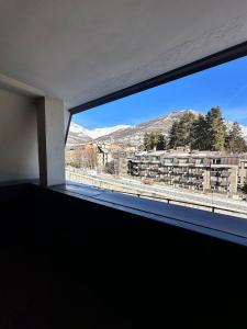 a window in a room with a view of a city at Trilocale Einaudi Bardonecchia in Bardonecchia +2 photos