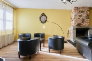 a waiting room with black chairs and a fireplace at La Casa De Anta in Asturianos