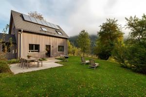 a barn with a table and chairs in a yard at Lug ins Tal - Ferienhaus in Baiersbronn
