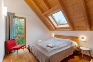 a bedroom with a large bed and a red chair at Lug ins Tal - Ferienhaus in Baiersbronn
