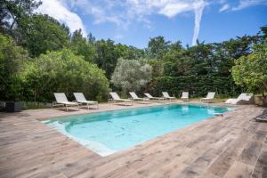 a swimming pool with chairs and a wooden deck at Studio moderne tout confort in La Valette-du-Var