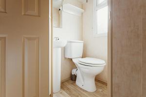 a bathroom with a white toilet and a sink at Villa Hexenholz in Thale +25 photos