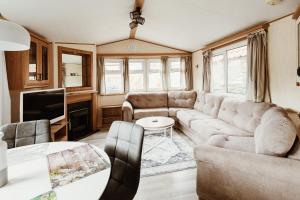 a living room with a couch and a tv at Villa Hexenholz in Thale
