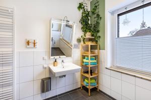 a bathroom with a sink and a mirror at Garten Apartment in Kerken +21 photos