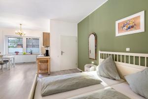 a bedroom with green walls and a bed and a table at Garten Apartment in Kerken