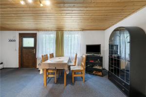 a dining room with a table and chairs and a television at Bungalow 19 - Kimbucht in Reichendorf