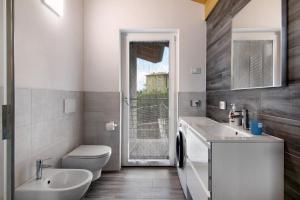 a bathroom with a sink and a toilet and a window at Jack House in Domaso +18 photos