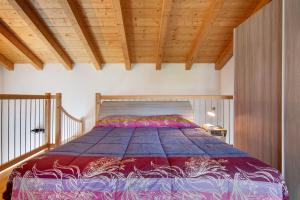 a bed in a bedroom with a wooden ceiling at Jack House in Domaso