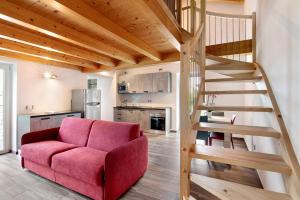 a living room with a red couch and a wooden staircase at Jack House in Domaso