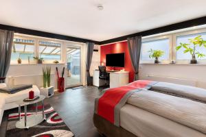 a bedroom with a large bed and a room with windows at Apartment Am Tobelbach in Oberlenningen