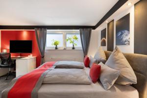 a bedroom with a bed and a desk and a television at Apartment Am Tobelbach in Oberlenningen