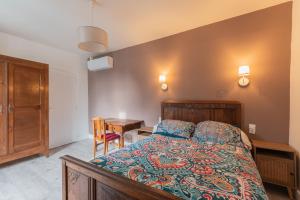 a bedroom with a bed and a desk and a table at La Maison Du Soleil L'aulhère in Oloron-Sainte-Marie
