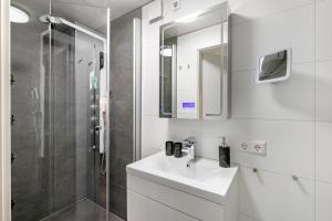a white bathroom with a sink and a shower at Apartment Am Tobelbach in Oberlenningen +20 photos