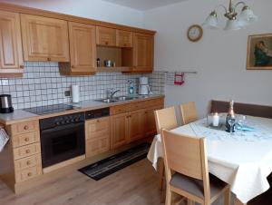 a kitchen with wooden cabinets and a table with a sink at Ferienwohnung Lienbacher in Abtenau
