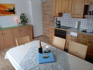 a kitchen with a table with a bottle of wine at Ferienwohnung Lienbacher in Abtenau +10 photos