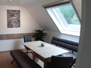 a dining room with a table and chairs and a window at Ferienwohnung Ruhrort in Brilon