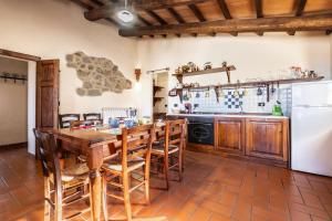 a kitchen with a wooden table and chairs at Genziana in Arcidosso