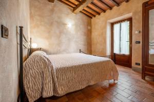 a bedroom with a bed in a room with a window at Casetta di Ugolino in Radicofani