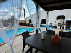 a patio with a table and chairs and a pool at Casa d’ avó Lita in Falcoeiras