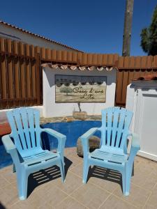 two blue chairs sitting on a patio with a sign at Casa d’ avó Lita in Falcoeiras