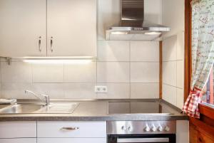 a small kitchen with a sink and a stove at Grashäusl in Grainau +17 photos