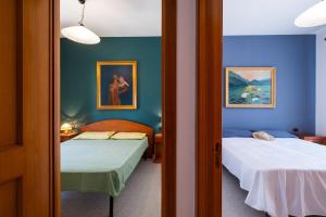 two beds in a room with blue walls at I Love Baia Verde spa in Baia Verde