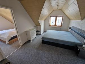 a attic bedroom with a bed and a window at Ferienwohnung Auenweg in Radebeul +12 photos