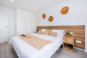 a bedroom with a large bed with white sheets and pillows at White suites in Cala d´Or