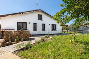 a white house with a stone wall at Su Carinniu in Villacidro