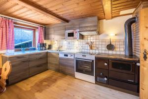 a kitchen with stainless steel appliances and wooden cabinets at Alpenchalet Bergprinzessin in Mühlen +19 photos
