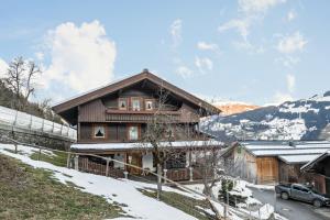 a house in the mountains with snow on the ground at Alpenchalet Bergprinzessin in Mühlen