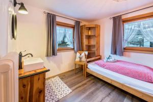 a bedroom with a bed and a sink at Alpenchalet Bergprinzessin in Mühlen