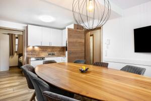 a kitchen and dining room with a wooden table and chairs at Good Life Top 3 in Saalbach-Hinterglemm