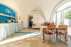a kitchen and dining room with a table and chairs at Agrumeto sul mare in Ostuni