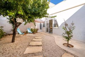 a courtyard with a tree and a stone path at Agrumeto sul mare in Ostuni
