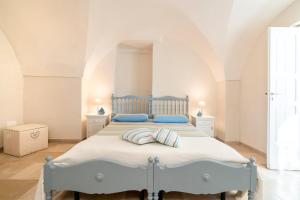 a bedroom with a blue bed with two pillows at Agrumeto sul mare in Ostuni