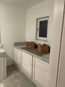 a bathroom with a counter with baskets and a mirror at Oberneulander Gästehaus in Bremen +12 photos