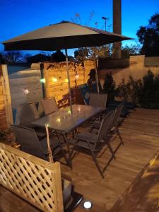 a table and chairs under an umbrella on a deck at Le Petit Marais in Échiré