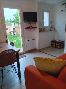 a living room with a couch and a tv at Le Petit Marais in Échiré