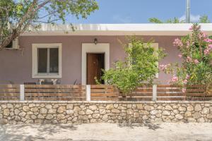 a house with a stone retaining wall and a fence at Stathis Home in Exanthia