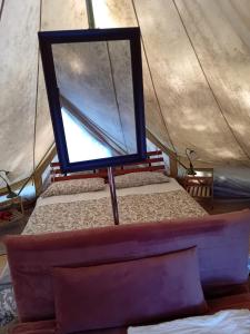 a mirror on a bed in a tent at Glamping C Selva Tenda Quercia in Piano Porlezza