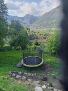 a tub in a field with mountains in the background at Glamping C Selva Tenda Quercia in Piano Porlezza